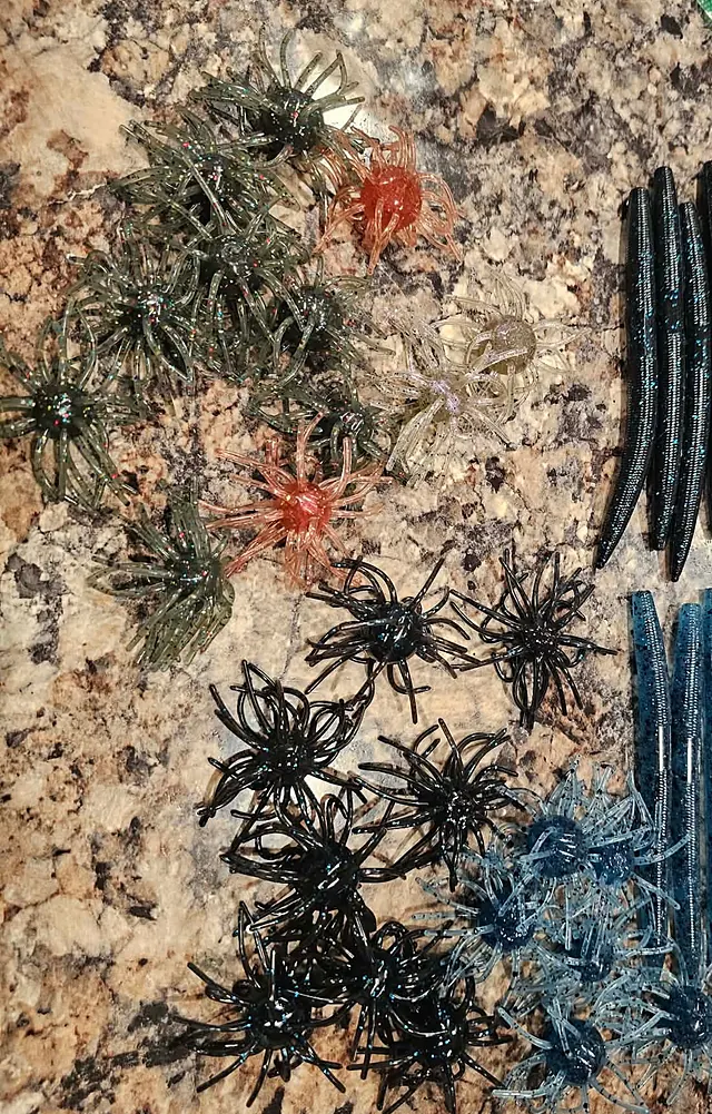 Urchin baits with dozens of curly legs in green, black, blue and orange next to blue stick worms